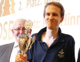 Hagen Poetsch mit dem Siegerpokal. Im Hintergrund Turnierleiter Thomas Wiedmann.