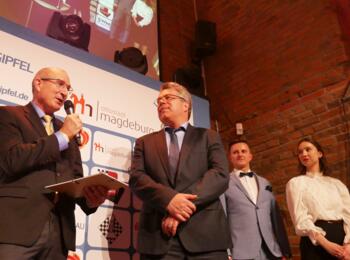 Gernot Gauglitz vom Hauptsponsor UKA mit DSB-Präsident Ullrich Krause. Im Hintergrund die beiden Moderatoren Daniel Wanzek und Julia Mätzkow.